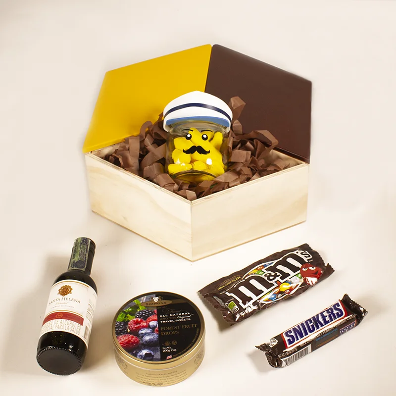 Caja con baso rellenos de gomas, vino Santa Helena Picolo, dulces, barra de chocolate y chocolates. 